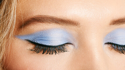 Close up image of female eyes with bright blue makeup