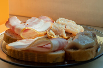Simple ham and fish sandwiches on a windowsill in the early morning