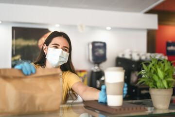 Fototapeta na wymiar Bar owner working only with take away orders during corona virus outbreak - Young woman worker wearing face surgical mask giving meal to customers - Healthcare and Food drink concept