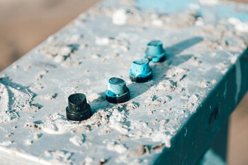 Black aerosol caps, spray cans stand on an old iron chtol smeared with paint