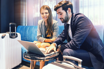 business travellers waiting for their flight at airport. beautiful business people checking airplane tickets while sitting on sofa in waiting lounge of airport. Coronavirus (COVID-19) pandemic .