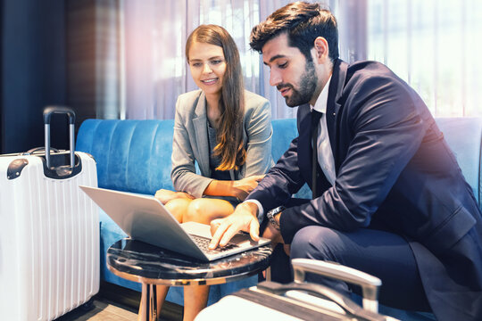 business travellers waiting for their flight at airport. beautiful business people checking airplane tickets while sitting on sofa in waiting lounge of airport. Coronavirus (COVID-19) pandemic .