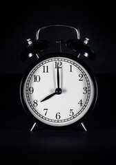 Retro vintage alarm clock on black background