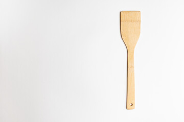 bamboo spatula for cooking on a white salted background.