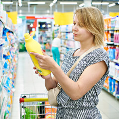 Woman chooses cleaning products in supermarket