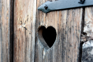 Heart shape at an old wooden door of a toilet