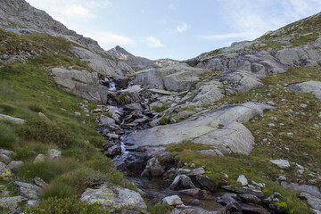 The view of mountain river flowing among stones, Italian Alps.