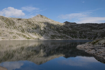 The view of mountain reflection in Lago della Vacca, Lombardy, Italy.