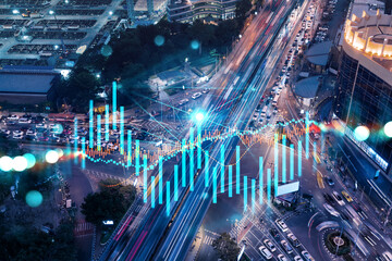 FOREX and stock market chart hologram on aerial view of road, busy urban traffic highway at night....