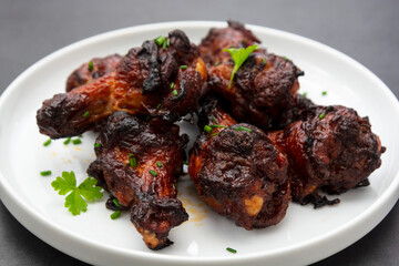 Barbecue roasted chicken legs, wings, drumsticks on plate, isolated.