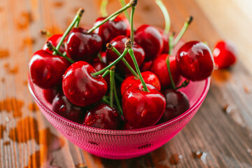 Fresh red cherries in bowl on wooden table