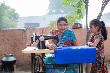 Mother and daughter sewing clothes with sewing machine
