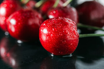 Fresh red cherries with water drops on dark background, close-up view