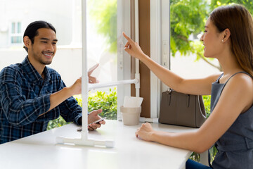Asian customers touch virtual screen for online menu.