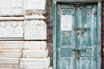 A wooden blue door next to a temple wall