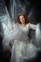 a red hair girl in a long white dress with plastic background