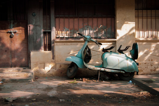 An abandoned house with an old scooter