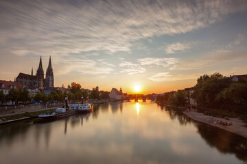 Fototapeta na wymiar Sonnenuntergang in Regensburg, Blick von der eisernen Brücke auf die steinerne Brücke mit tollen Wolken