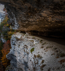 Walking path under a rock ledge in Alps mountains. Dangerous hiking trail on a cliff face. Nature exploring in Slovenia