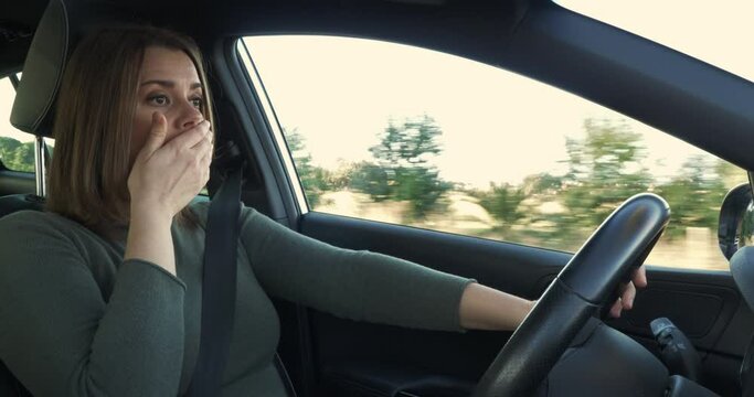 Woman driving car tired yawning dangerous