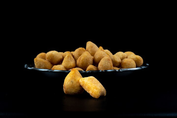 fried party snacks arranged on a stainless steel plate with black background