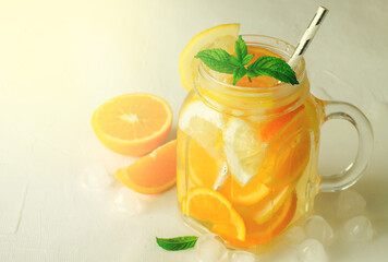 Summer refreshing iced drinks with orange, lemonand mint on white background