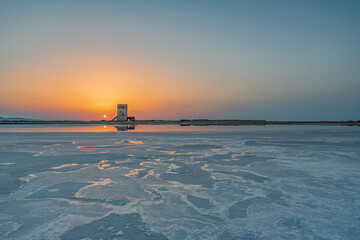Sole che tramonta dietro la torre di Nubia, Saline di Trapani IT