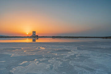 Sole che tramonta dietro la torre di Nubia, Saline di Trapani IT