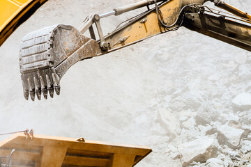 track type excavator industrial scoop loading dumper truck. engineer working with excavator at open mine ore