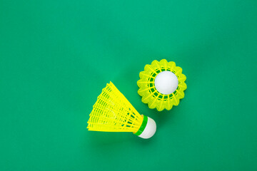 Two shuttlecock for badminton on a green background, top view.