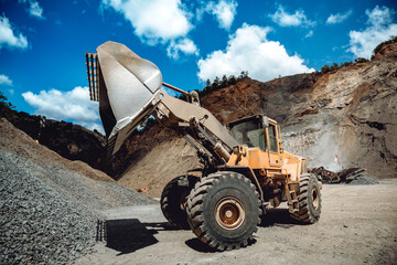 Fototapeta premium Industrial heavy duty wheel loader working on construction site. Industrial machinery loading and transporting gravel
