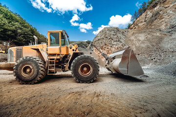 Heavy duty wheel loader excavator working in ore quarry. Mining industry.