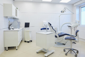 An interior of a dental office with white and blue furniture. Dentist’s office.