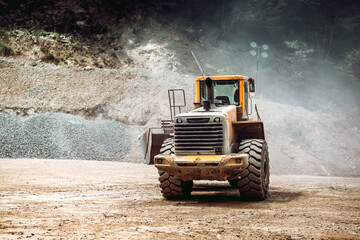 heavy duty industrial wheel loader loading rock and  ore at crushing and sorting plant. Quarry details