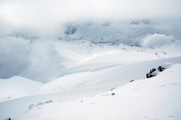 Fototapeta na wymiar Cloudy winter mountainous landscape. The greater Caucasus mountain range. Gudauri ski resort. Georgia.