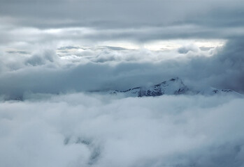 Fototapeta na wymiar Cloudy winter mountainous landscape. The greater Caucasus mountain range. Gudauri ski resort. Georgia.