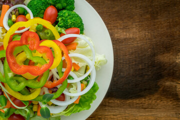 Vegetable salad healthy food on white plate on wooden background.