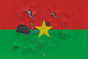 Burkina Faso flag close up old, damaged and dirty on wall peeling off paint to see inside surface. Vintage National Concept.