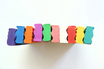 pieces of colored plasticine different colors on a white background