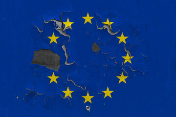 European Union flag close up old, damaged and dirty on wall peeling off paint to see inside surface. Vintage National Concept.