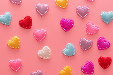 Multi-colored hearts on a pink background.
