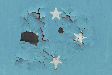 Micronesia flag close up old, damaged and dirty on wall peeling off paint to see inside surface. Vintage National Concept.