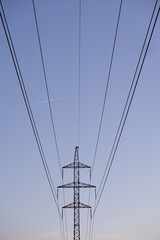high voltage power lines and contrails of the plane