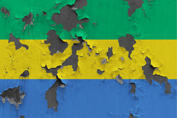 Gabon flag close up painted, damaged and dirty on wall peeling off paint to see concrete surface. Vintage National Concept.