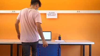Young student man with medical face mask going back to school after the coronavirus. Social distancing measures for the reopening and adaptation of schools and academies to the new normal. - Powered by Adobe