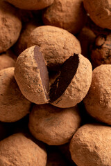 Pile of sweet truffle candies in cocoa powder close-up.