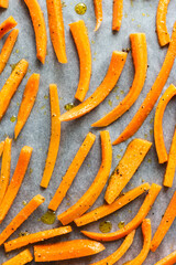 Fresh orange carrot sticks with pepper and olive oil ready for baking