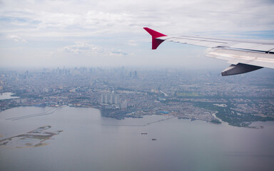The plane flies against the background of the city of Jakarta. Indonesia.
