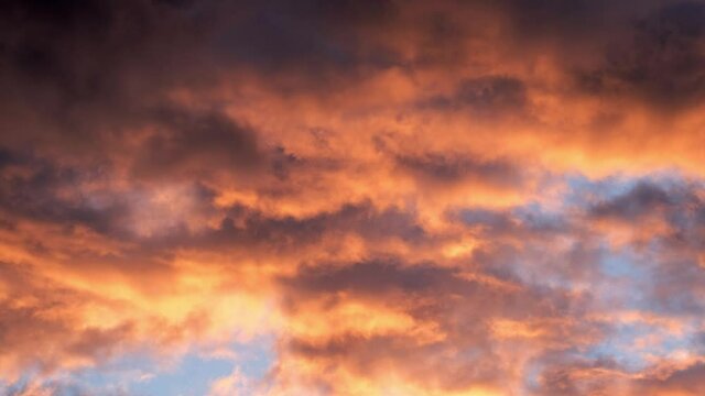 4K timelapse loops with dramatic orange sunset on dark cloudy sky