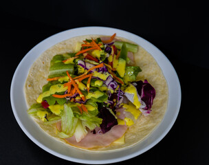 Ham, mozzarella cheese, and vegetables covered with honey mustard on flour tortilla
